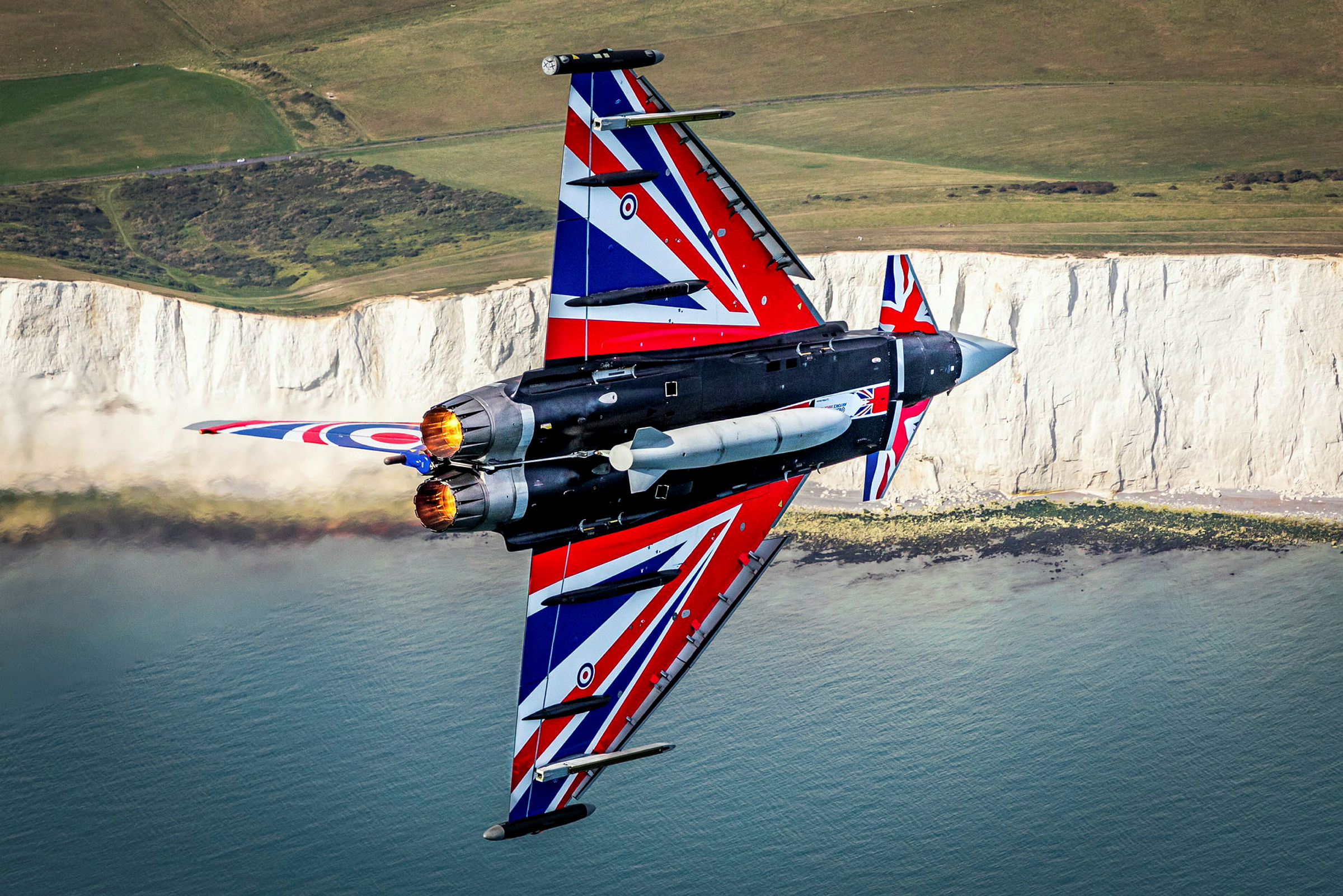 Typhoon with Union Jack paintwork flying over dover cliffs.